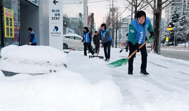 많은 눈이 내린 지난 2월 박병규 광산구청장과 공직자, 주민들이 함께 눈을 치우고 있다.