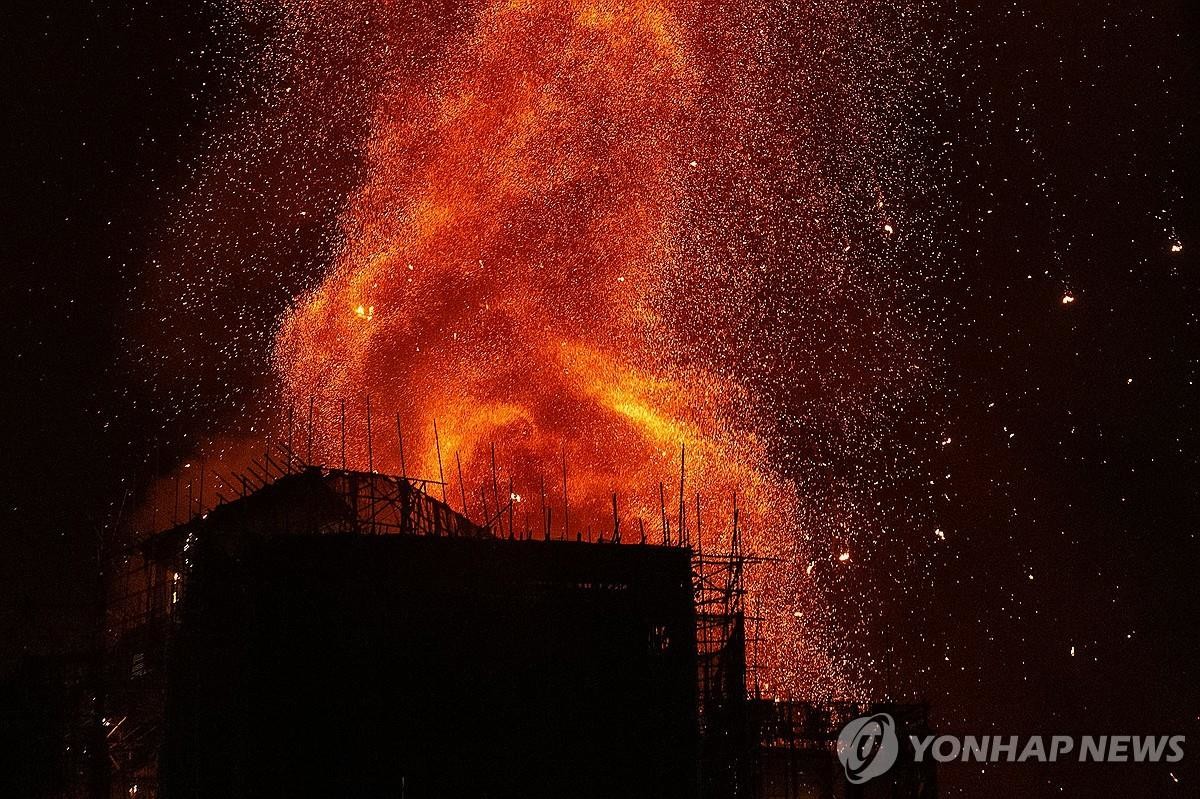 26일 오후 홍콩 북부 타이포 구역의 고층 아파트단지에서 불이 나 일대에 붉은 연기가 번지고 있다. / AP-연합뉴스