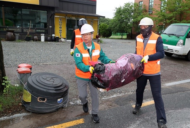 박병규 광산구청장이 생활폐기물 수거 현장을 찾아 환경직 노동자들과 종량제 봉투를 나르고 있다.