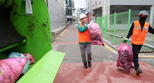박병규 광산구청장이 생활폐기물 수거 현장을 찾아 환경직 노동자들과 종량제 봉투를 나르고 있다.