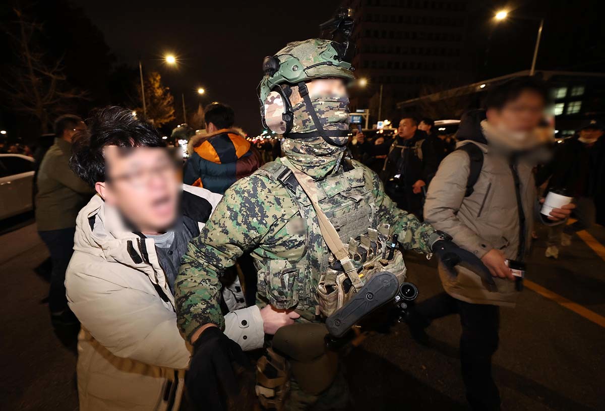 지난해 12월 4일 서울 여의도 국회 본청 앞에서 시민이 계엄을 저지하고 있다. / 뉴스1