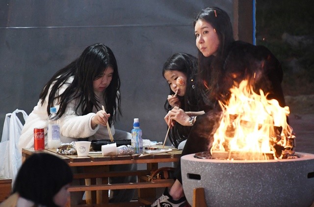한 가족이 함평엑스포공원 함평겨울빛축제장에서 불멍을 하면서 겨울밤을 즐기고 있다.