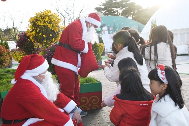 산타가 어린이들에게 사탕을 나눠주고 있다.