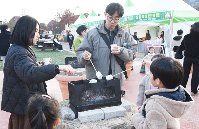 관광객들이 마시멜로를 구워먹고 있다.