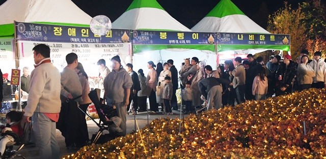 관광객들이 먹거리 부스에서 줄을 서서 대기하고 있다.