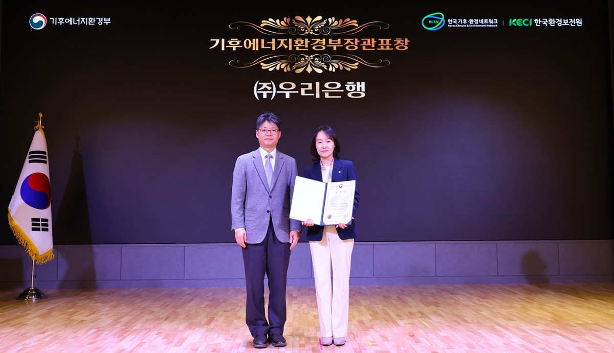 우리은행이 2일 ‘2025 탄소중립 생활 실천 국민대회’에서 기후에너지환경부장관 표창받은 뒤, 이현주 우리은행 ESG상생금융부장(오른쪽)과 오일영 기후에너지환경부 기후에너지정책실장이 함께 기념촬영을 하고 있다. / 우리은행