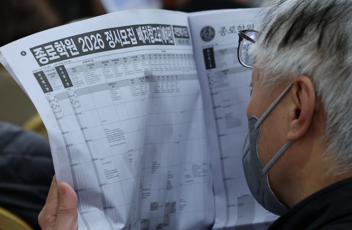 수능점수 분석 및 정시 합격점수예측 긴급설명회를 찾은 학부모가 정시모집 배치참고표를 살펴보고 있다. / 뉴스1