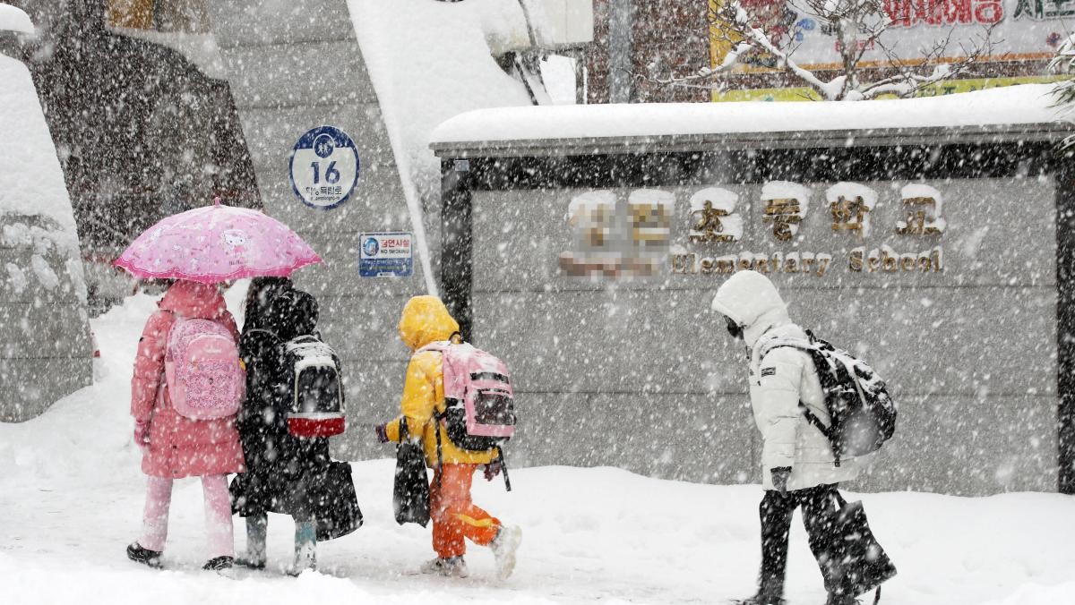 광주 서구 화정동 한 초등학교 아이들이 눈 길을 걸어 등교하고 있다.  / 연합뉴스