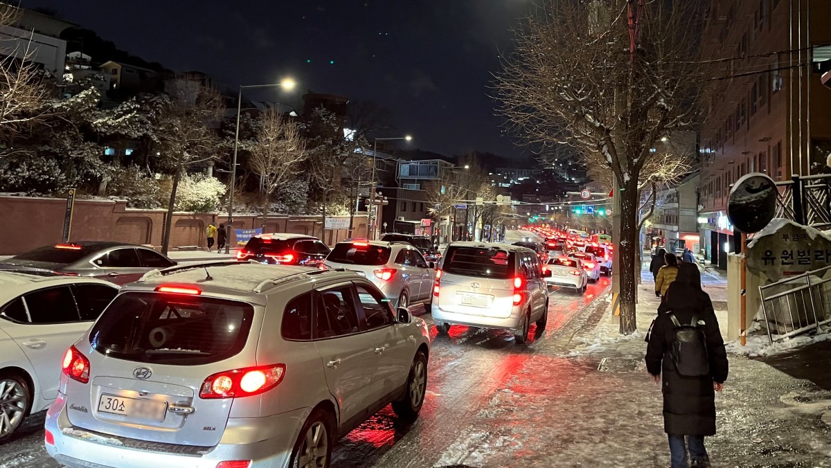 지난 4일 서울 종로구 자하문로에서 차량들이 눈길에 큰 정체를 빚자 시민들이 버스에서 내려 걸어가고 있다.     / 뉴스1