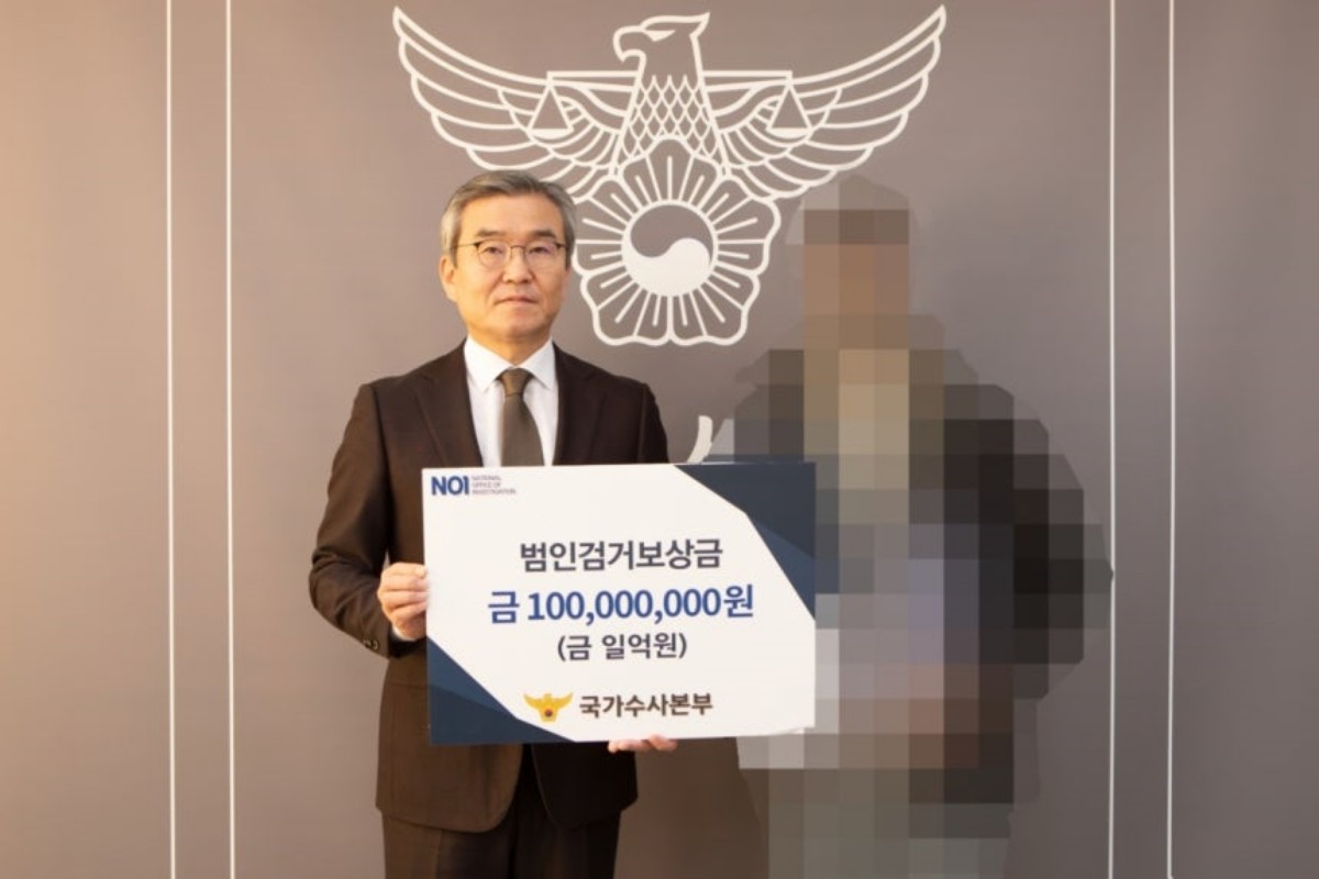 박성주 경찰청 국가수사본부장(왼쪽)이 투자리딩방 사기 조직을 검거하는 데 결정적 제보를 한 시민에게 보상금 1억원을 지급하며 기념 촬영을 하고 있다 / 경찰청 제공