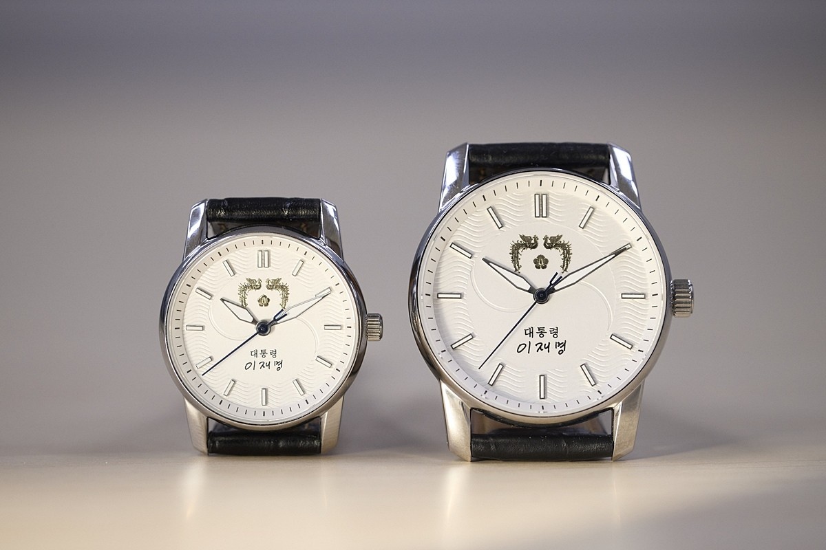 이재명 대통령 손목시계. 대통령실은 5일 이재명 대통령의 취임 6개월을 맞아 '대통령 손목시계'를 공개했다. 대통령실에 따르면 전통적인 대통령 손목시계와 마찬가지로 앞면에는 대통령 휘장과 함께 이재명 대통령의 서명이 들어갔으며 시계판 바탕에는 태극 문양이 새겨졌다. 손목시계 뒷면에는 이 대통령의 자필 글씨체로 '국민이 주인인 나라'라는 문구가 각인됐다. / 대통령실 제공