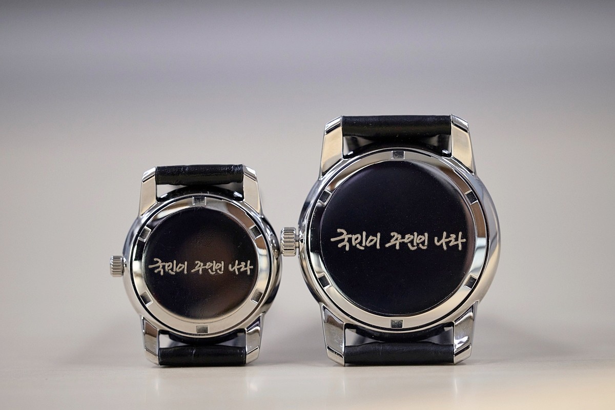 이재명 대통령 손목시계. 대통령실은 5일 이재명 대통령의 취임 6개월을 맞아 '대통령 손목시계'를 공개했다. 대통령실에 따르면 전통적인 대통령 손목시계와 마찬가지로 앞면에는 대통령 휘장과 함께 이재명 대통령의 서명이 들어갔으며 시계판 바탕에는 태극 문양이 새겨졌다. 손목시계 뒷면에는 이 대통령의 자필 글씨체로 '국민이 주인인 나라'라는 문구가 각인됐다.     / 대통령실 제공