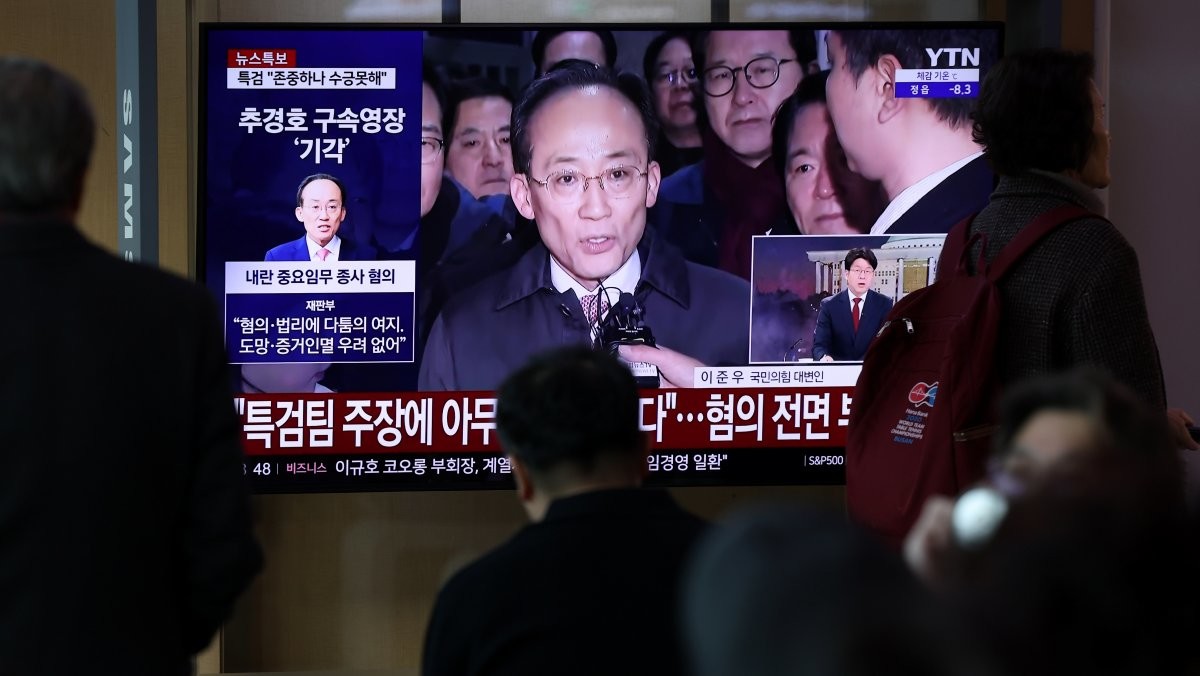 12·3 비상계엄 1년을 맞은 3일 오전 서울 중구 서울역 대합실에서 시민들이 비상계엄 해제 표결 참여를 방해한 혐의를 받는 추경호 국민의힘 의원의 구속영장 기각 관련 뉴스를 지켜보고 있다. / 뉴스1