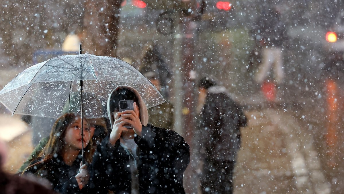 첫눈이 내린 지난 4일 오후 서울 중구 명동을 찾은 관광객들이 내리는 눈을 맞으며 즐거운 시간을 보내고 있다. / 뉴스1