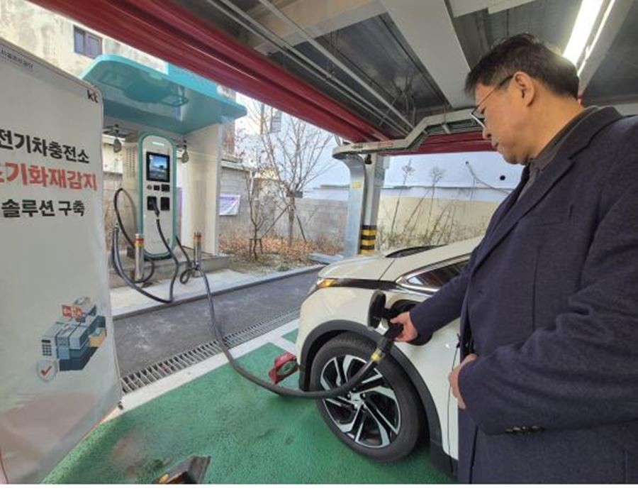 조기화재감지 솔루션이 설치된 전기 충전소에서 한 시민이 전기차 충전 중이다. (사진 속 하단 빨간색 이미지가 세이프메이트 ‘IoT복합 화재감지기’) /     KT대구경북광역본부 제공