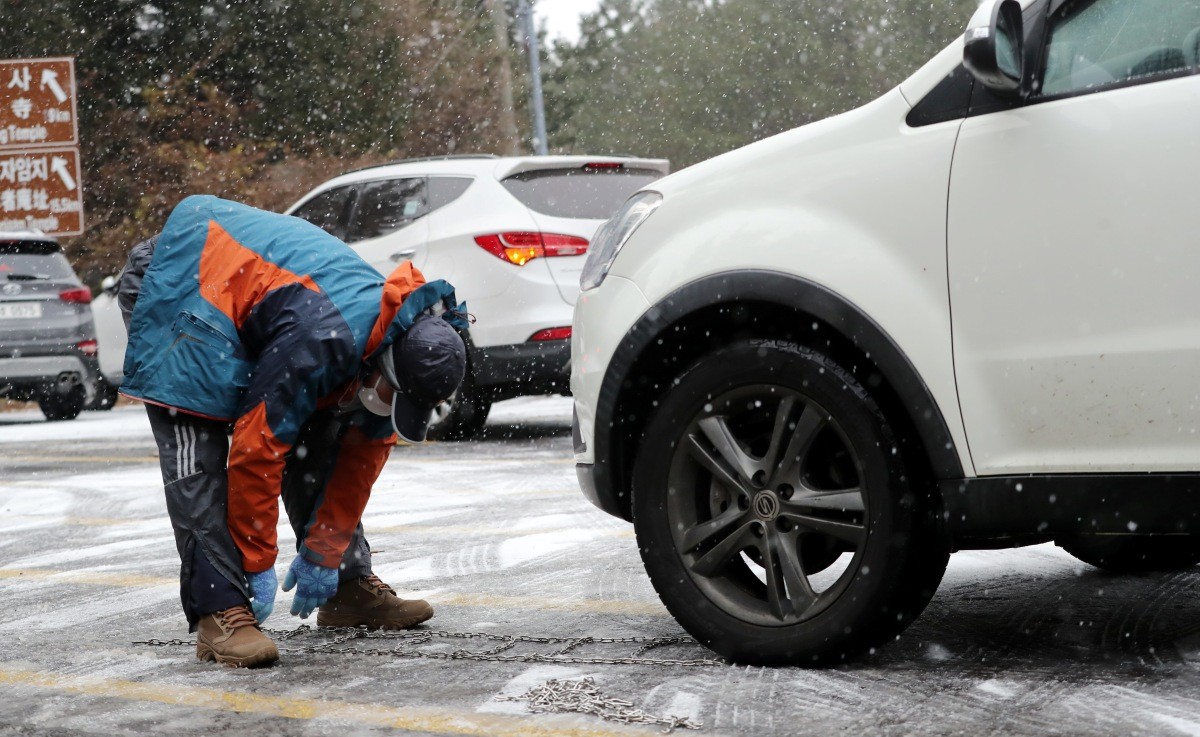 차량 운전자가 체인을 장착하고 있다. 기사의 이해를 돕기 위한 사진 / 뉴스1