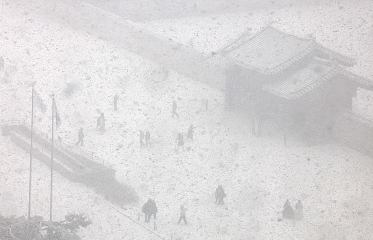 서울에 대설주의보가 내려진 날 서울 종로구 경복궁에서 시민들이 눈을 맞으며 길을 걷고 있다. 기사 이해를 돕기 위한 자료 사진 / 뉴스1