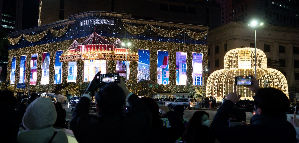서울 명동거리를 찾은 시민들이 신세계백화점 본점 외벽 조명을 감상하며 연말 분위기를 만끽하고 있다 / 뉴스1