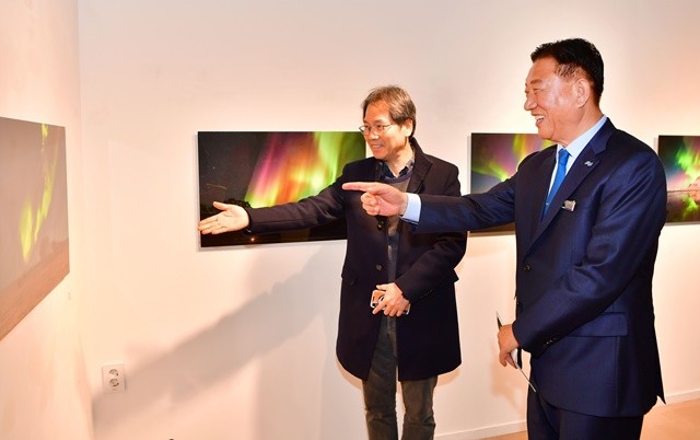사진전을 찾은 김한종 군수(우)가 조경원 작가로부터 작품 설명을 듣고 있다. 장성군 제공
