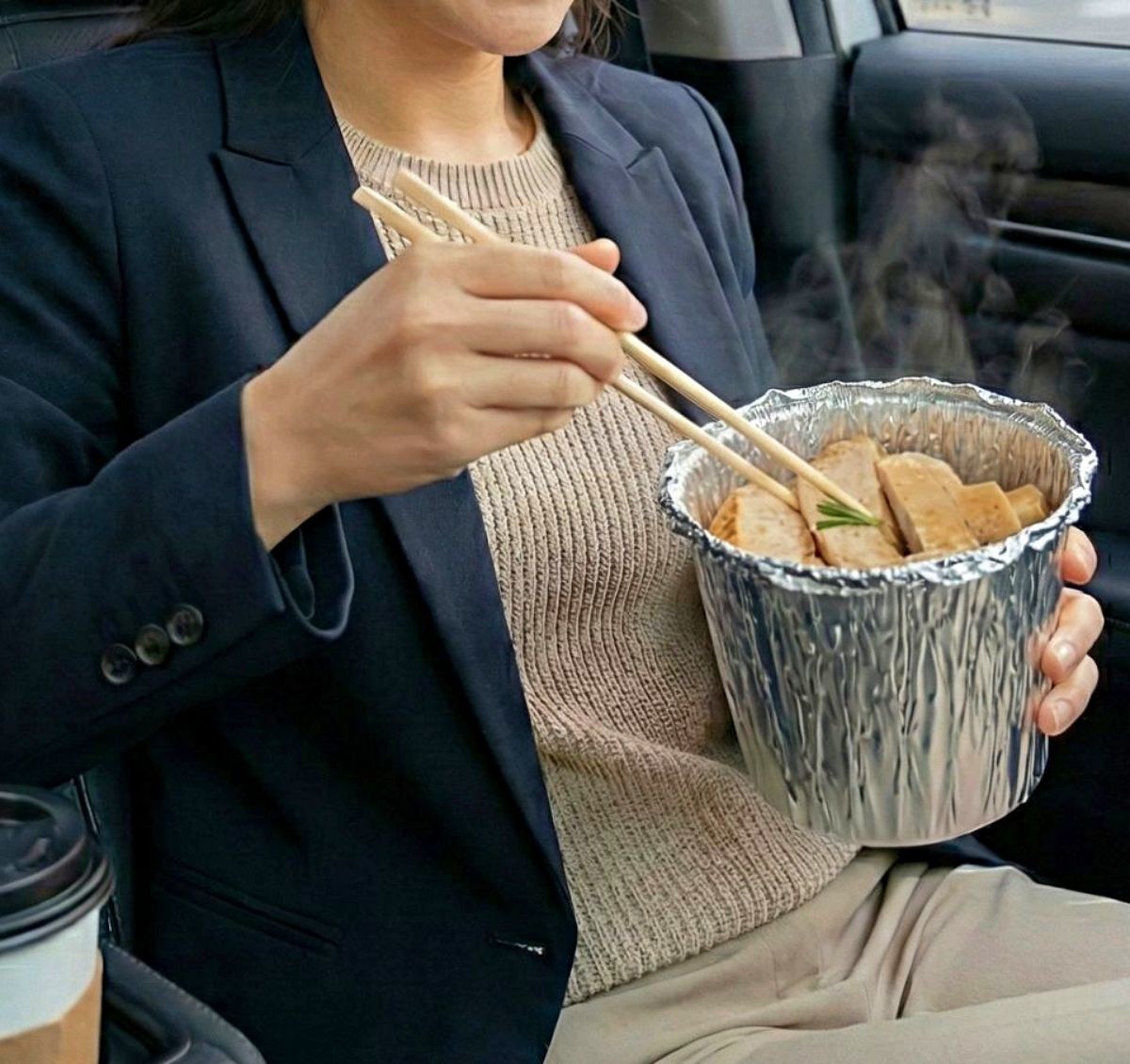 휴지와 쿠킹호일 활용해 만든 간편한 일회용 보온 용기로 이동 중 차 안에서 닭가슴살 식단 챙겨 먹는 직장인. 이 용기는 음식을 다 먹은 후 바로 버릴 수 있다는 장점이 있다. 기사 내용을 바탕으로 제작한 자료사진.