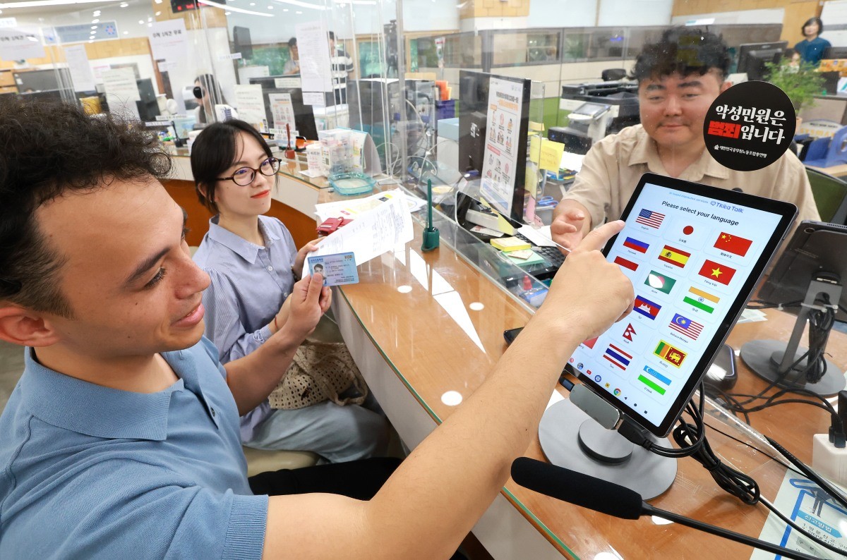 유성구청을 방문한 외국인이 AI 기반 통번역기를 활용해 체류지 변경 신고를 하고 있다. / 유성구