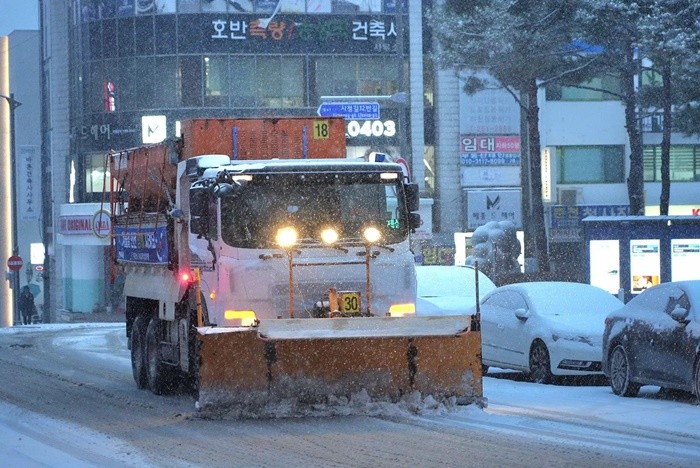 23일 오후 강원 춘천 일대에 많은 눈이 내리는 가운데 제설 차량이 도로 제설 작업을 진행하고 있다. / 뉴스1