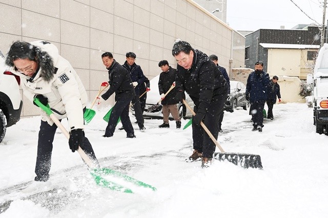 김산 군수와 공무원들이 무안읍 시가지에서 제설 작업을 하고 있다