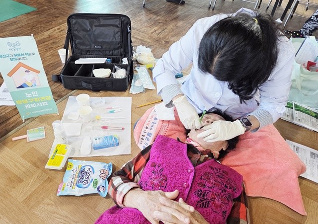 광산구 보건소 관계자가 거동이 불편한 어르신의 가정을 방문해 맞춤형 구강 건강 관리 서비스를 제공하고 있다.