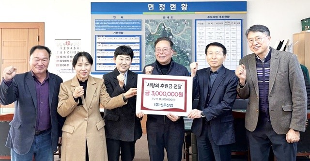 ㈜신우산업 하태영 대표(왼쪽 네 번째)가 공산면행정복지센터에서 공산초등학교와 공산중학교를 위한 후원금을 전달하고 있다