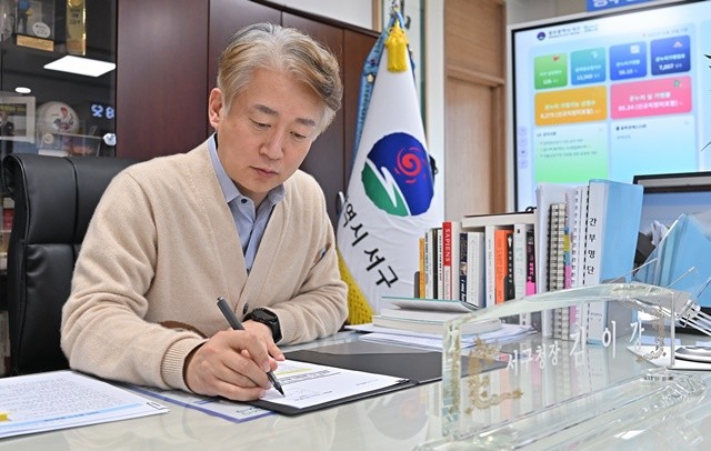 김이강 광주 서구청장이 2일 2026년 새해 제1호 안건으로, 14억 원 규모의 ‘서구 골목페이 페이백 추진계획’에 서명하고 있다.