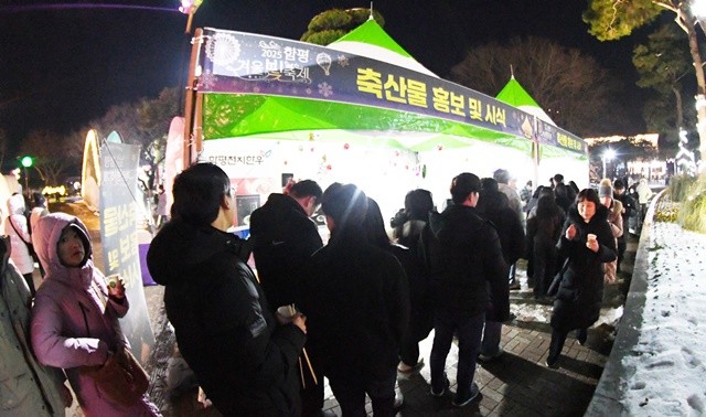 3일 전남 함평엑스포공원 ‘함평겨울빛축제’ 현장에서 열린 함평산 돼지고기 시식회에 참여하기 위해 관광객들이 길게 줄을 서서 차례를 기다리고 있다.