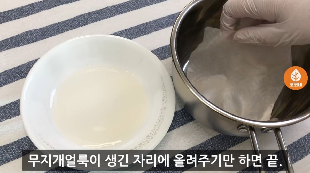 식초에 적힌 키친타월에 '무지개 얼룩'이 생긴 곳에 올려준 모습. / 유튜브 '코코네'