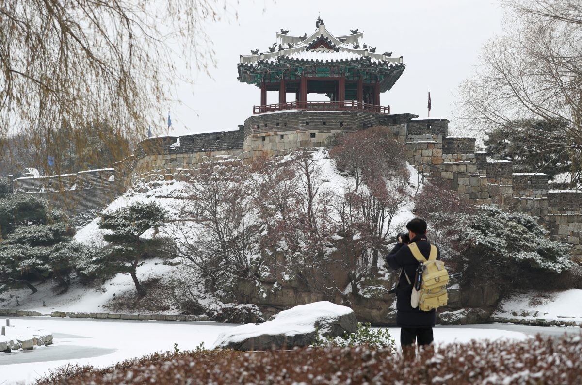 경기 수원시 장안구 수원화성 용연에서 한 시민이 눈 덮인 방화수류정을 카메라로 촬영하고 있다. / 뉴스1