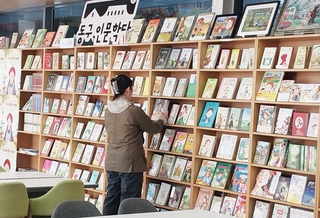 광주 동구 인문학당에서 열리고 있는 ‘빨강머리 앤 특별전’을 찾은 어린이와 가족들이 다양한 버전의 책을 신기한 듯 둘러보고 있다.