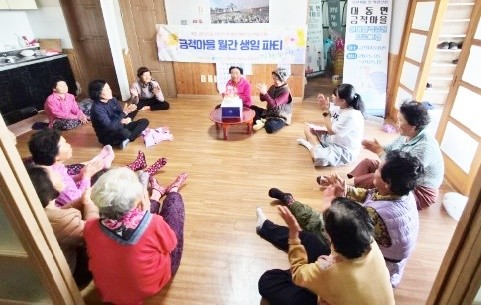 함평군 대동면 금적마을에서 열린 ‘찾아가는 생일파티’에서 생일을 맞은 한 어르신이 이웃들의 축하를 받으며 환하게 웃고 있다.