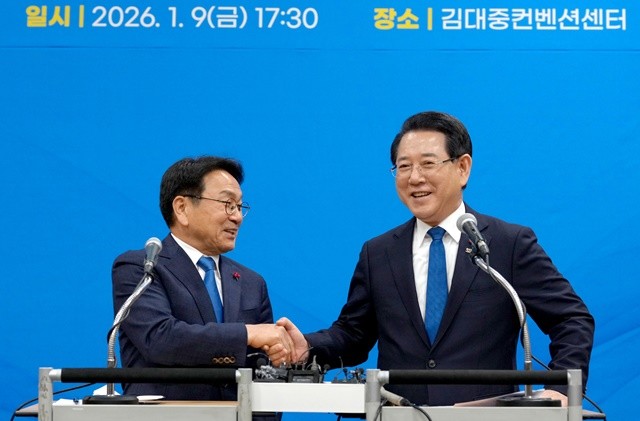 김영록 전남도지사가 9일 오후 광주 서구 김대중컨벤션센터에서 열린 ‘광주·전남 행정통합 시도민 보고회’에서 강기정 광주광역시장에게 행정통합에 동의해 주신 것에 대한 감사의 악수를 청하고 있다.