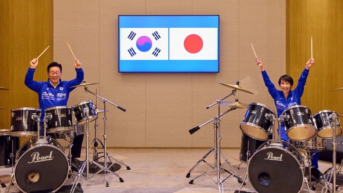 이재명 대통령과 다카이치 사나에 일본 총리가 13일 일본 나라현 회담에서 푸른색 유니폼을 함께 착용하고 즉석 드럼 협주를 하고 있다. 청와대는 이날 한일 정상회담과 관련해 '다카이치 총리가 이재명 대통령에게 드럼 스틱을 선물하고, 즉석에서 드럼 연주 방법을 직접 설명하며 합주를 이끌었다'고 밝혔다. / 뉴스1
