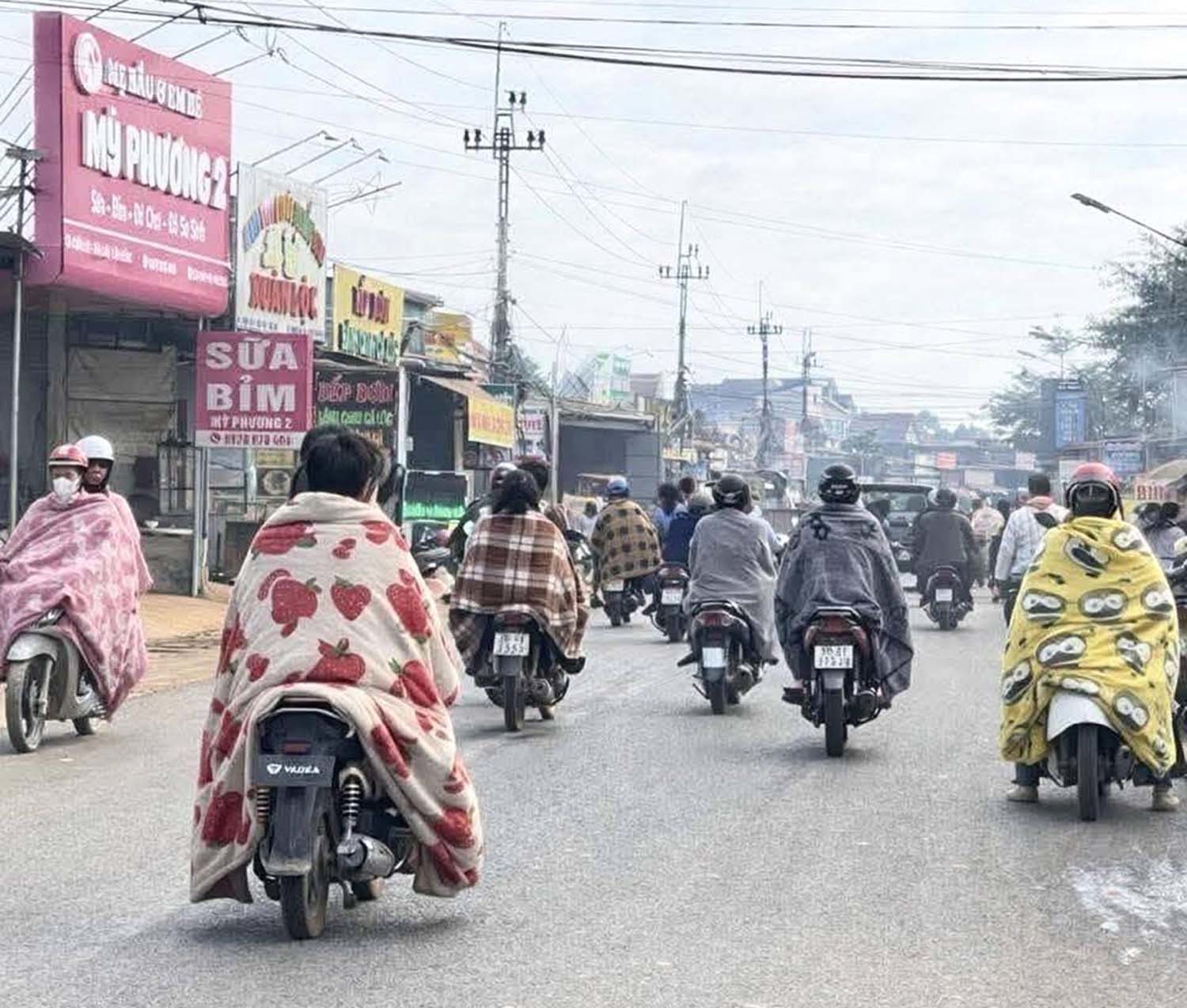 베트남인들이 담요를 두르고 오토바이를 타고 있다. / X