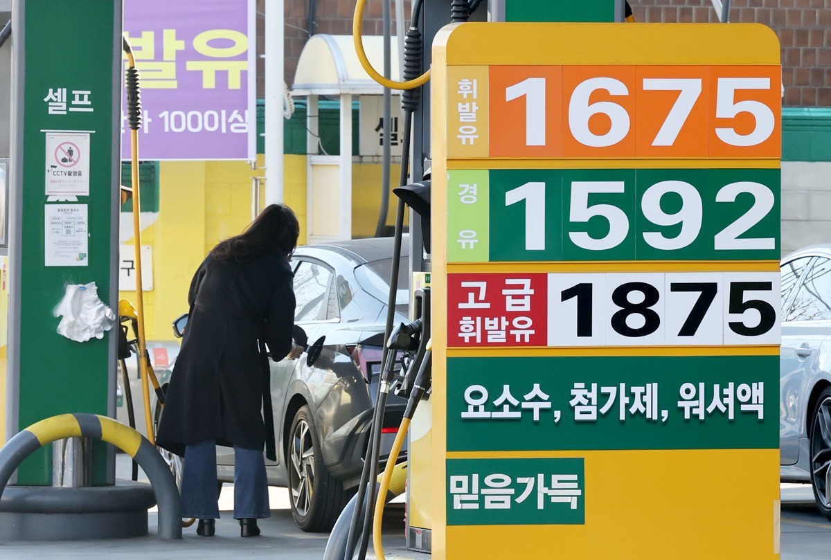 서울에 있는 한 주유소에서 시민이 주유하고 있다.     토요일인 17일 한국석유공사 유가정보시스템 오피넷에 따르면 1월 둘째 주(11∼15일) 전국 주유소 휘발유 평균 판매가는 지난주보다 1L당 14.5원 내린 1706.3원으로 나타났다.     / 뉴스1