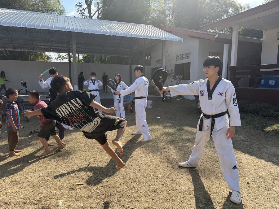 계명대학교 라오스 국외봉사단이 방비엥 푸딘뎅 초등학교에서 태권도 교육봉사를 하고 있다. / 계명대학교 제공