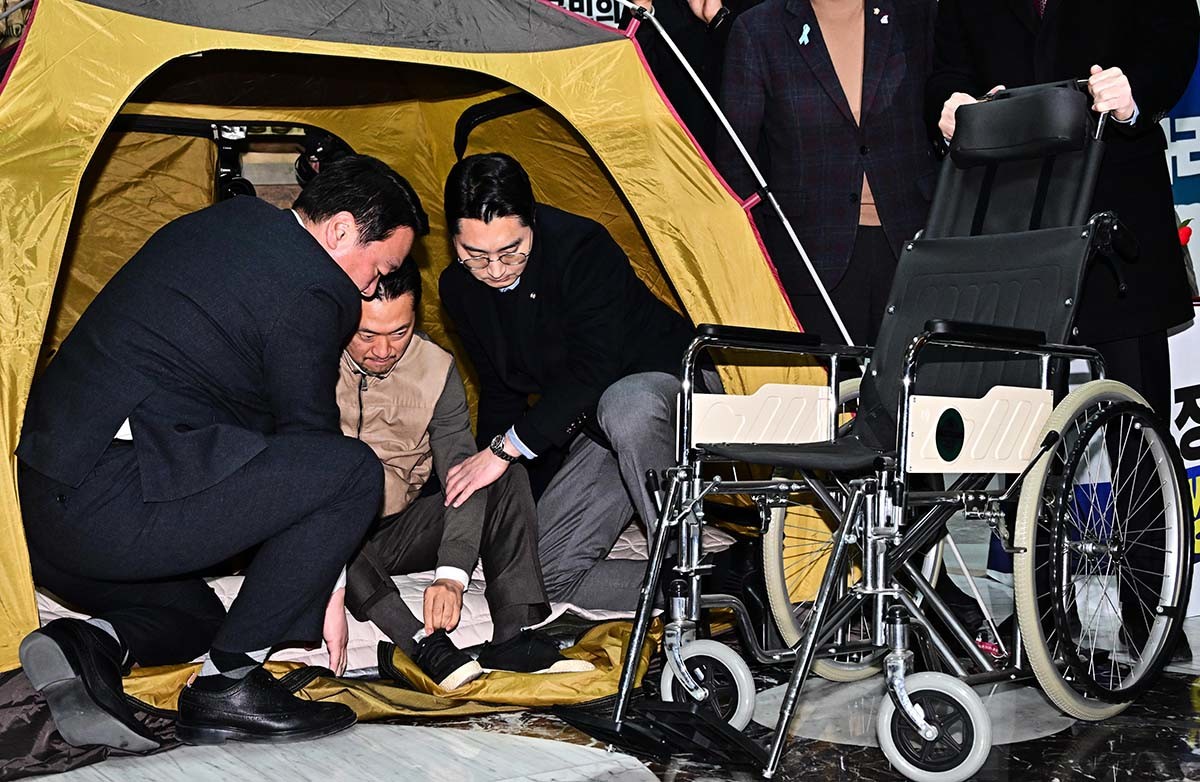 '통일교·공천헌금' 쌍특검법 수용을 촉구하며 8일째 단식을 이어오던 장동혁 국민의힘 대표가 22일 서울 여의도 국회 로텐더홀에서 단식 중단을 선언한 뒤 휠체어에 오르고 있다. / 뉴스1