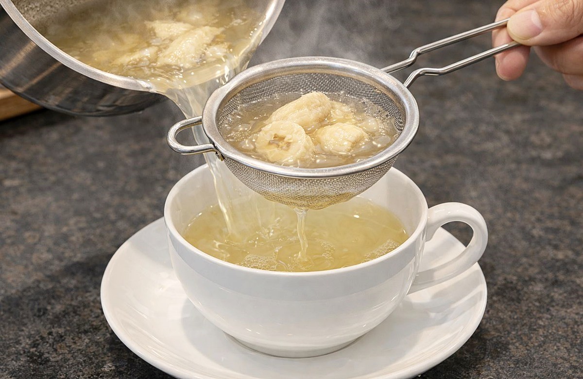 바나나를 끓인 물을 체에 거르는 모습. 기사 이해를 돕기 위해 AI를 활용해 제작한 자료 사진입니다. 실제 모습과 다소 차이가 있을 수 있습니다.