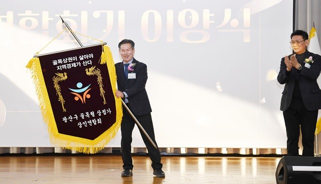 박형국 제4대 광산구 골목형상점가 상인연합회 회장이 연합회기를 흔들고 있다.