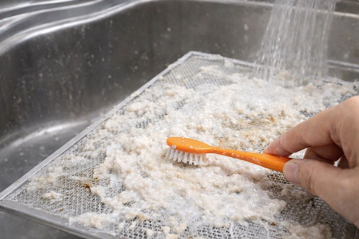 밀가루와 소주를 섞은 반죽으로 주방 후드를 세척하는 모습. 기사 이해를 돕기 위해 AI를 활용해 제작한 자료 사진입니다. 실제 모습과 다소 차이가 있을 수 있습니다.