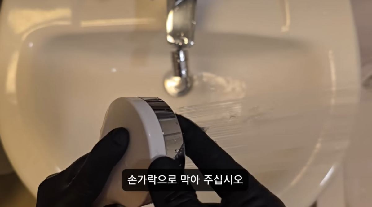 물줄기가 삐져나오는 부분을 손가락으로 가볍게 눌러 막는 모습. / 유튜브 '살림하는 부산아빠'