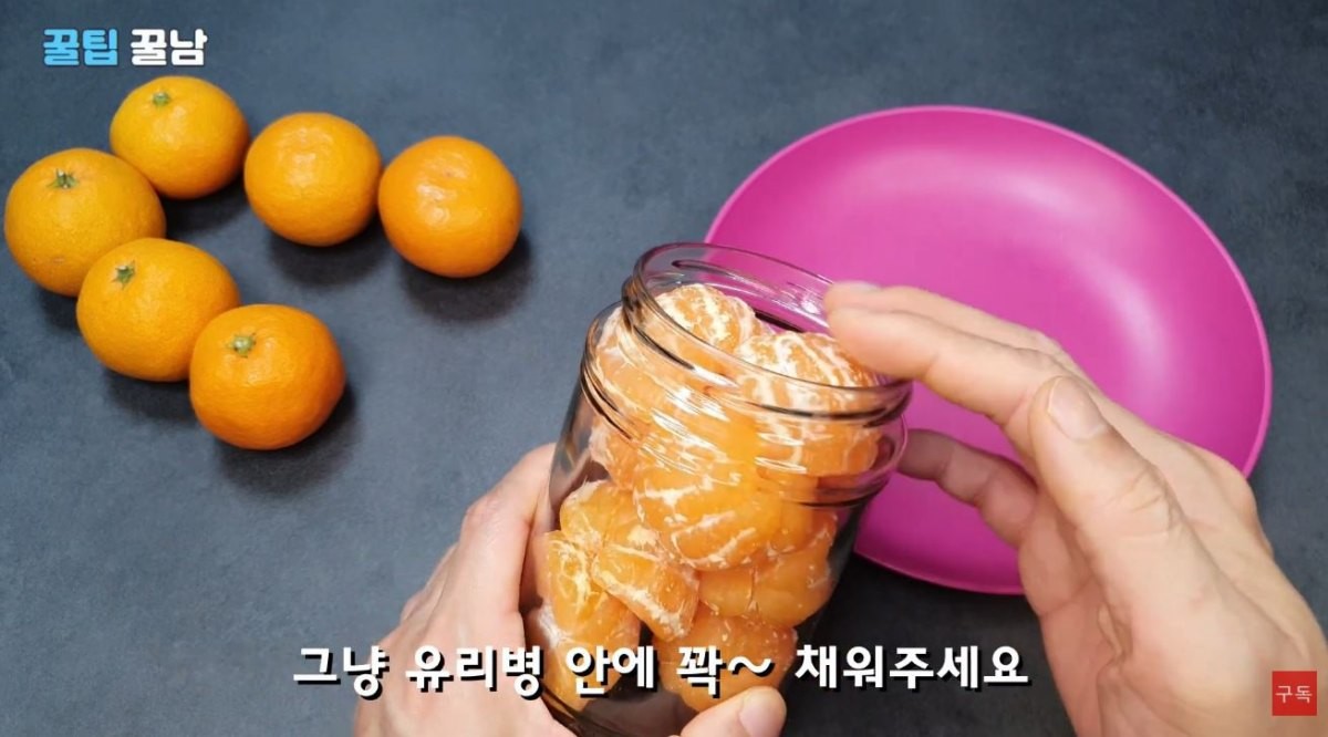 껍질을 깐 귤을 유리병에 채워넣는 모습. / 유튜브 '꿀팁알려주는남자, 꿀팁꿀남 Honey tips man'