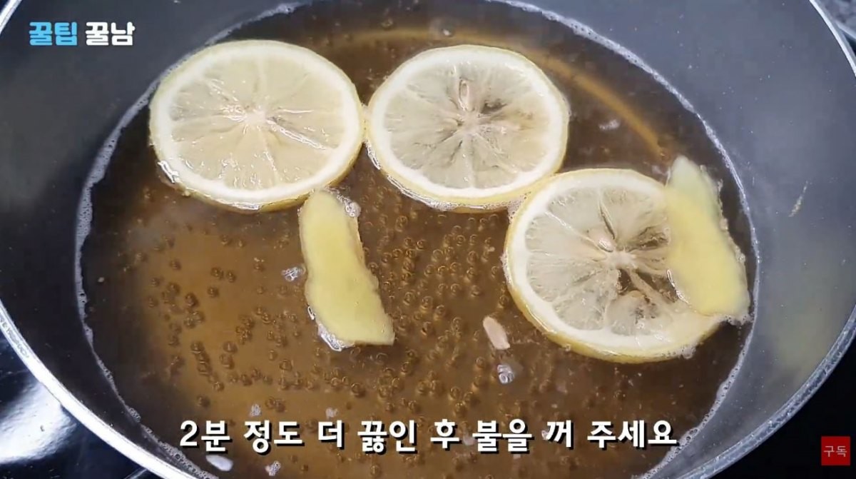 귤에 따랐던 물을 10분 후 다시 추출해 슬라이스한 생강과 레몬 3조각 등을 넣고 끓이는 모습. / 유튜브 '꿀팁알려주는남자, 꿀팁꿀남 Honey tips man'
