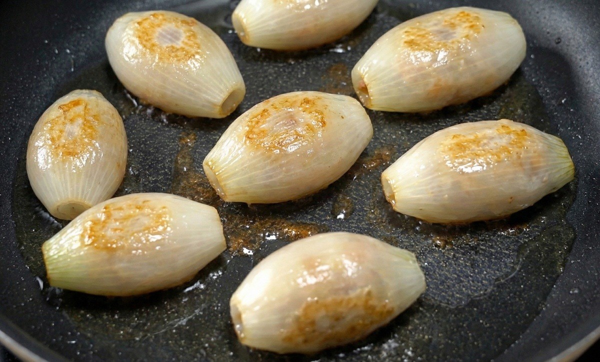 AI툴로 제작한 프라이팬에 구운 양파피 만두 자료사진.