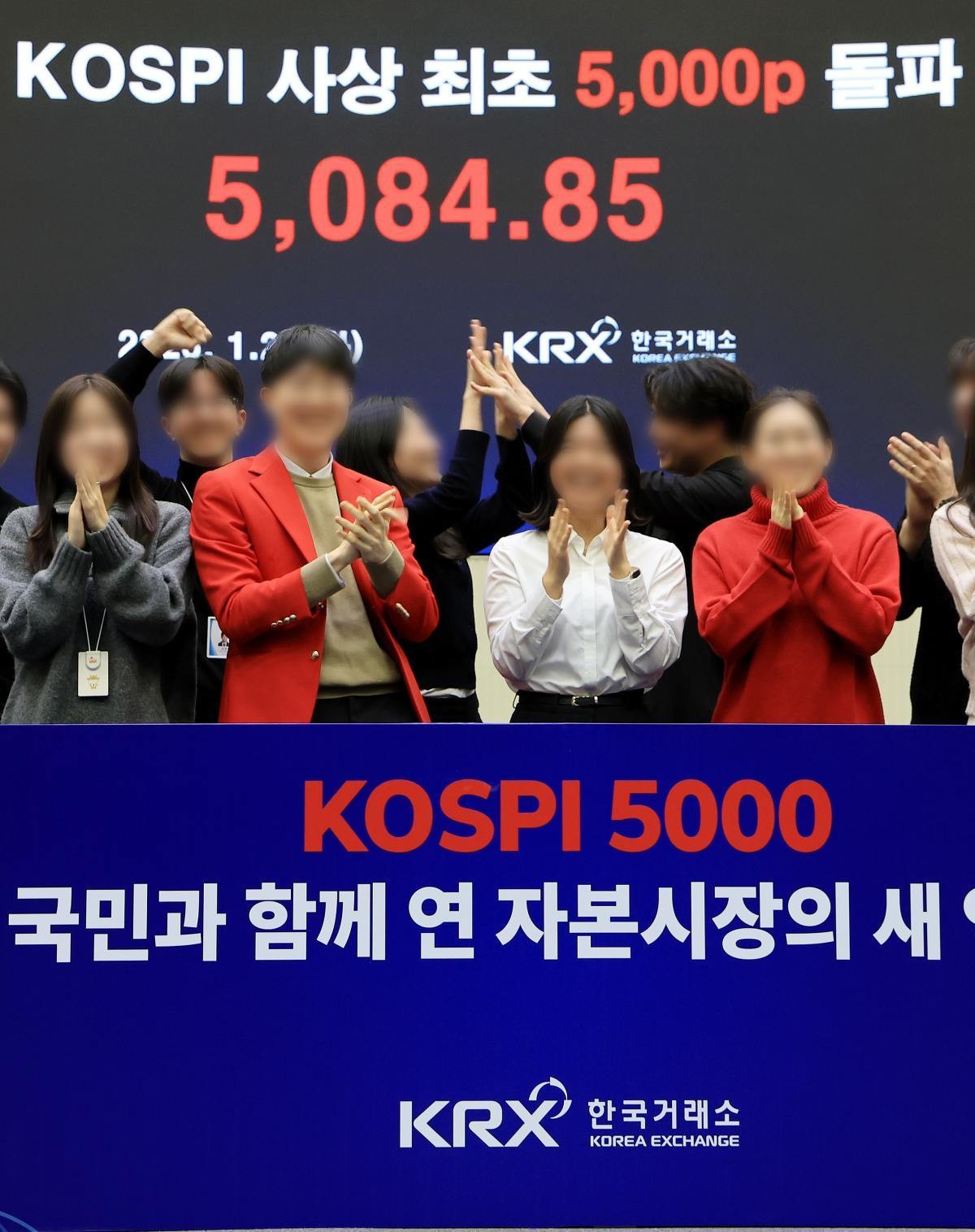 한국 증시 최초로 종가 기준 코스피 5000을 달성한 지난 27일 서울 영등포구 한국거래소에서 직원들이 코스피 종가가 표시된 전광판을 배경으로 세레머니를 하고 있다. / 뉴스1