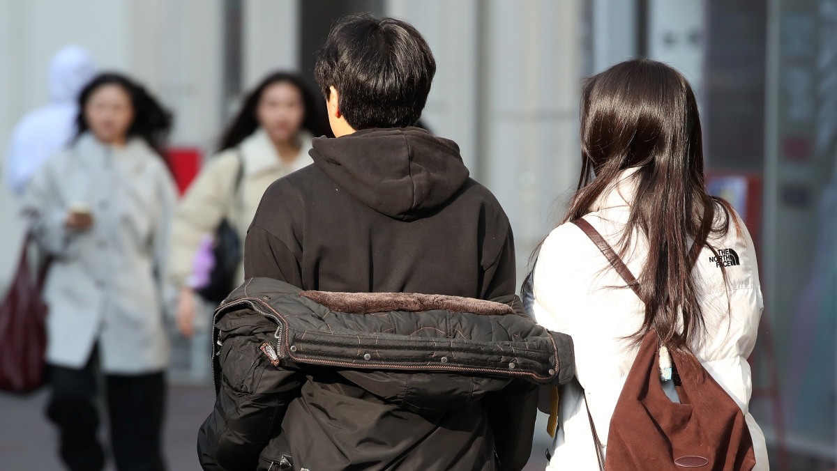 한 시민이 외투를 반쯤 벗어 걸친 채 걸어가고 있다. 기사의 이해를 돕기 위한 사진 / 뉴스1